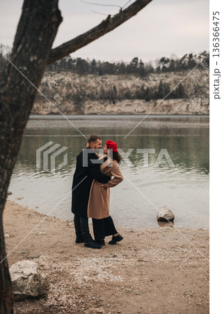 Couple shares a romantic moment by the lake on Valentines Day with beautiful scenery surrounding them 136366475
