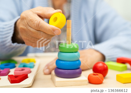 Alzheimer disease AD, Asian elderly woman patient suffering from dementia learn practical motor skills rehabilitation. Alzheimer disease AD, Asian elderly woman patient suffering from dementia learn practical motor skills rehabilitation. 136366612