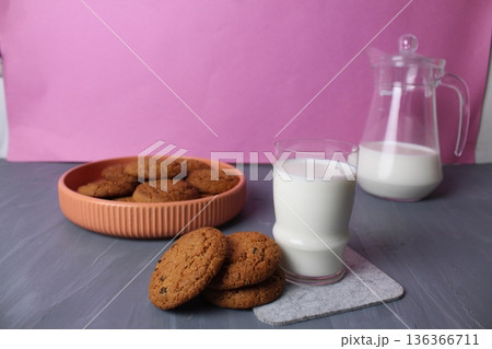 Healthy breakfast: oatmeal cookies, a glass of milk, a jug on a gray background with space for text, copyspace. Truck concept. Healthy breakfast: oatmeal cookies, a glass of milk, a jug on a gray background with space for text, copyspace. Truck concept. 136366711
