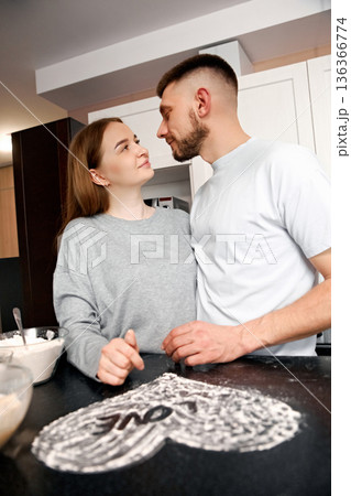 Couple enjoys cooking together in a kitchen while preparing a dessert at home during an afternoon 136366774