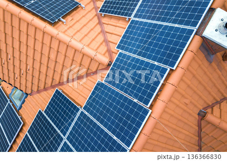 Aerial top view of new modern residential house cottage with blue shiny solar photo voltaic panels system on roof. Renewable ecological green energy production concept. 136366830