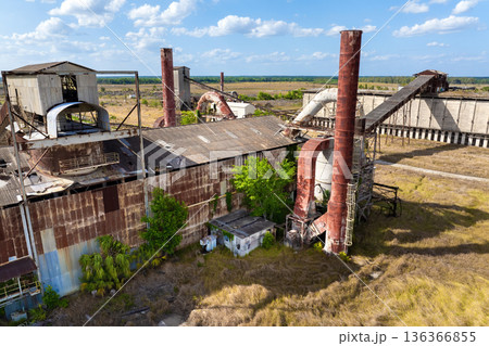 Old phosphate processing plant in central Florida with weathered structure, conveyor belts and overgrown vegetation. Old phosphate processing plant in central Florida with weathered structure, conveyor belts and overgrown vegetation. 136366855