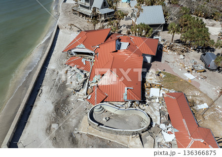 Storm surge severe damage to residential houses on ocean shore after hurricane landfall. Natural disaster consequences in Florida Storm surge severe damage to residential houses on ocean shore after hurricane landfall. Natural disaster consequences in Florida 136366875