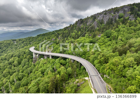 Viaduct bridge on winding parkway road in mountain forest with green canopies in summertime. Driving in North Carolina wild woods nature in summer 136366899