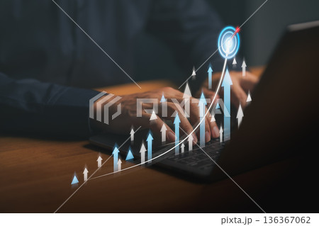 Hands typing on laptop keyboard with digital growth arrows and target icon, symbolizing business success, data analytics, online marketing performance, and financial progress concept. Hands typing on laptop keyboard with digital growth arrows and target icon, symbolizing business success, data analytics, online marketing performance, and financial progress concept. 136367062
