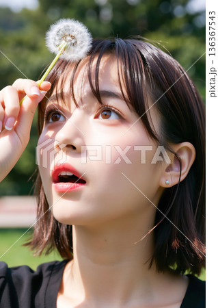 たんぽぽで遊ぶ女性 136367543