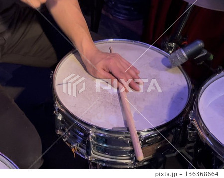 クローズドリムショットでドラムを演奏する手 136368664