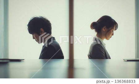 職場の疎外感とコミュニケーションの断絶を象徴する沈黙の男女 136368833