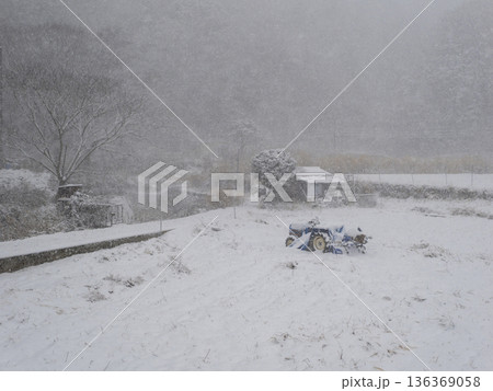 雪が積もる田畑とトラクターの風景 雪が積もる田畑とトラクターの風景 136369058
