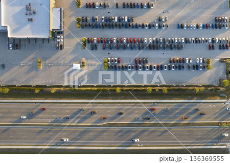 Large parking lot of local dealer with many brand new cars parked for sale on highway roadside. Development of american automotive industry and distribution of manufactured vehicles concept 136369555