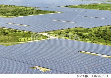 Aerial view of big sustainable electric power plant with many rows of solar photovoltaic panels for producing clean electrical energy. Renewable electricity with zero emission concept Aerial view of big sustainable electric power plant with many rows of solar photovoltaic panels for producing clean electrical energy. Renewable electricity with zero emission concept 136369601