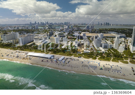 Aerial view of South Beach sandy surface with tourists relaxing on hot Florida sun. Miami Beach city with high luxury hotels and condos. Tourism infrastructure in southern USA Aerial view of South Beach sandy surface with tourists relaxing on hot Florida sun. Miami Beach city with high luxury hotels and condos. Tourism infrastructure in southern USA 136369604