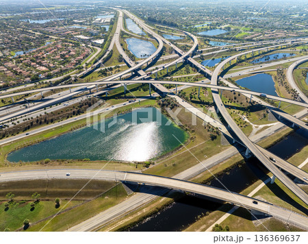 Miami freeway interchange with elevated road lanes for fast express driving of cars. Vehicles driving on huge complex expressway junction Miami freeway interchange with elevated road lanes for fast express driving of cars. Vehicles driving on huge complex expressway junction 136369637