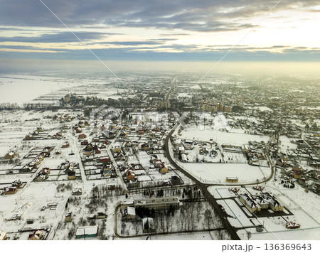 Top view of city suburbs or small town nice houses on winter morning on cloudy sky background. Aerial drone photography concept. 136369643