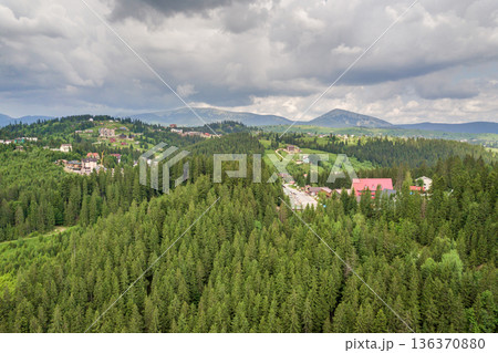 Aerial view of green Carpathian mountains covered with evergreen spruce pine foreston summer sunny day. Aerial view of green Carpathian mountains covered with evergreen spruce pine foreston summer sunny day. 136370880