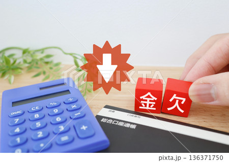 電卓と通帳で表現する金欠と家計悪化のイメージ。 136371750