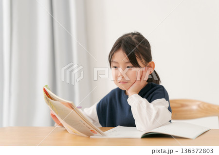 頬杖をついて勉強をする小学生の女の子 頬杖をついて勉強をする小学生の女の子 136372803