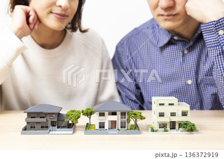 住宅模型を見ながら話し合いをする夫婦 136372919
