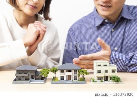 住宅模型を見ながら話し合いをする夫婦 136372920