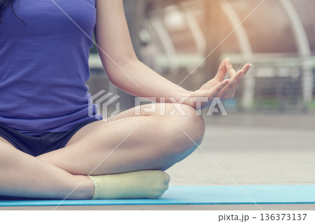 Yoga fitness lifestyle healthy woman relaxation doing a meditation. Yoga meditate outdoor with zen sitting position. Yoga woman workout in sportswear sit on yoga mat home fitness Yoga fitness lifestyle healthy woman relaxation doing a meditation. Yoga meditate outdoor with zen sitting position. Yoga woman workout in sportswear sit on yoga mat home fitness 136373137