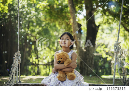 Happy Child hug teddy bear in green park playground. Teddy bear best friend for little kids cute girl. Autism happy funny playing together on playground in happiness family feel love and warm hugs Happy Child hug teddy bear in green park playground. Teddy bear best friend for little kids cute girl. Autism happy funny playing together on playground in happiness family feel love and warm hugs 136373215