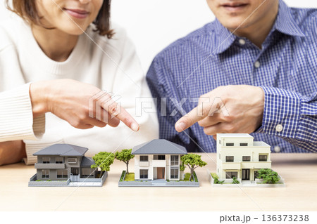 住宅模型を見ながら話し合いをする夫婦 住宅模型を見ながら話し合いをする夫婦 136373238