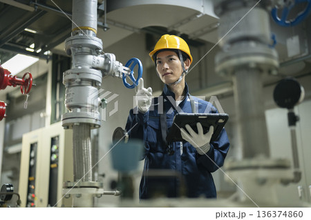 タブレットを使って点検作業を行うビルメンテナンススタッフ 136374860