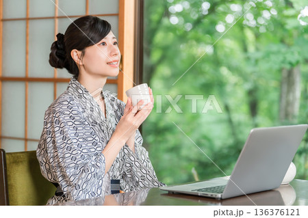 旅館の和室でお茶を飲む浴衣姿の若いアジア人女性 旅館の和室でお茶を飲む浴衣姿の若いアジア人女性 136376121