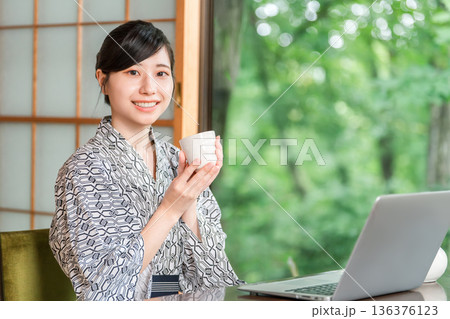 旅館の和室でお茶を飲む浴衣姿の若いアジア人女性 旅館の和室でお茶を飲む浴衣姿の若いアジア人女性 136376123