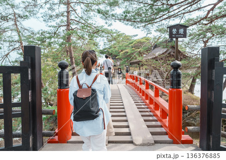 Woman tourist walking cross Sukashibashi bridge to the Zuiganji Godaido or National Treasure, a temple building on a small island in Matsushima Bay in Matsushima, Miyagi Prefecture, Tohoku, Japan 136376885