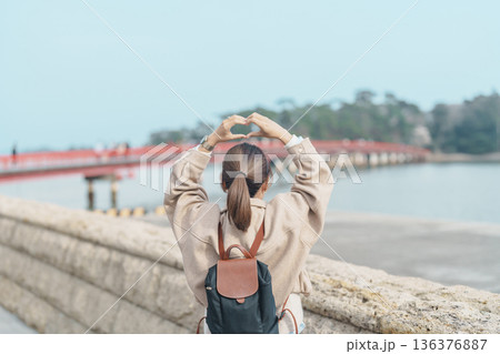 Woman tourist sightseeing Fukuura jima bridge or the bridge of romantic encounters for Fukuura Island at Matsushima Bay in Matsushima, Miyagi Prefecture, Tohoku, Japan. Landmark and famous Vacation 136376887