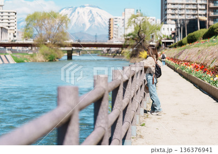 Woman tourist sightseeing Iwate mountain and Kitakami river with flowers in Spring, happy traveler travel in Morioka city, Iwate prefecture, Japan. famous Landmark Travel and Vacation destination 136376941