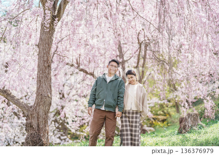 Couple tourist sightseeing Sakura Cherry Blossom in Spring, happy traveler travel in Tendo Park or Maizuru Park in Yamagata prefecture, Tohoku, Japan. famous Landmark for Travel and Vacation 136376979