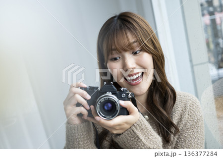 一眼レフカメラを買った若い女性 136377284