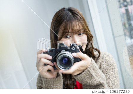 一眼レフカメラで写真を撮る若い女性 一眼レフカメラで写真を撮る若い女性 136377289
