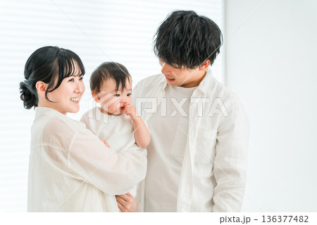 家で赤ちゃんを抱っこする若いアジア人夫婦,ファミリー,親子,家族 136377482