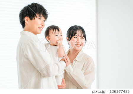 家で赤ちゃんを抱っこする若いアジア人夫婦,ファミリー,親子,家族 136377485