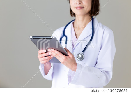 タブレットを持つ白衣姿のミドル女性看護師 136378681