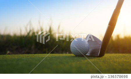 Golf clubs and balls on a green lawn in a beautiful golf course with morning sunshine. Golf clubs and balls on a green lawn in a beautiful golf course with morning sunshine. 136378698