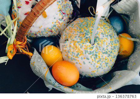 Easter cake with painted eggs and candles in a basket. Easter still life. Orthodox Eater celebration. Colourful Easter eggs with sweet cake and lit candles. Spring religious holiday. Easter cake with painted eggs and candles in a basket. Easter still life. Orthodox Eater celebration. Colourful Easter eggs with sweet cake and lit candles. Spring religious holiday. 136378763