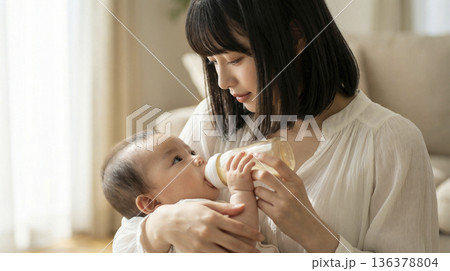 室内で赤ちゃんに哺乳瓶でミルクをあげて授乳をしている日本人の母親 136378804