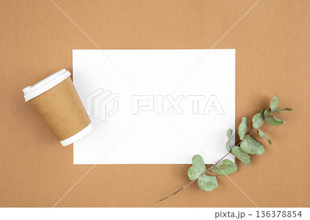 Craft paper coffee cup and eucalyptus sprig on eco background, flat lay. Craft paper coffee cup and eucalyptus sprig on eco background, flat lay. 136378854