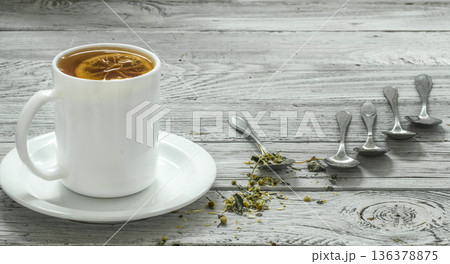 Cup of tea and spoons on a beautiful white wooden background, winter ,autumn 136378875