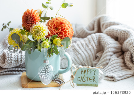 Easter composition with a bouquet of flowers and a knitted element. Easter composition with a bouquet of flowers and a knitted element. 136378920