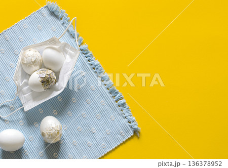 Easter composition with Easter eggs in a protective mask from the coronavirus top view. 136378952