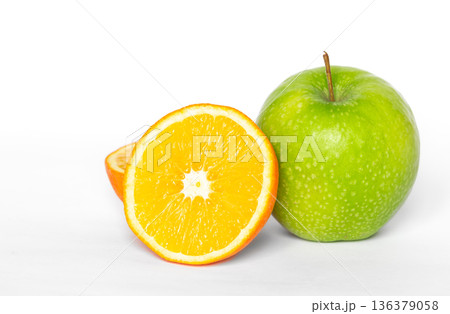 Green apple and orange on a white background isolated. 136379058