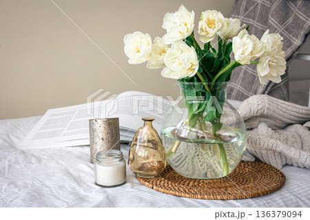 Home composition with a bouquet of tulips in a glass vase and candles. Home composition with a bouquet of tulips in a glass vase and candles. 136379094