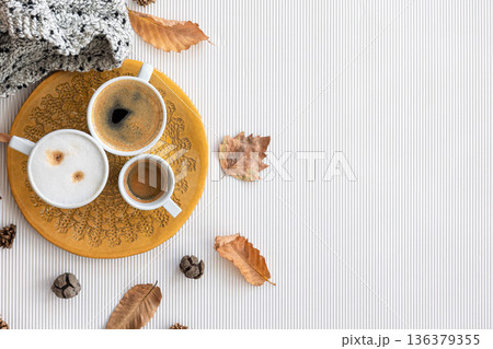Autumn composition with cups of coffee and leaves on a white background. Autumn composition with cups of coffee and leaves on a white background. 136379355