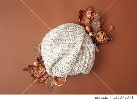 Autumn composition with dry leaves and white round knitted element copy space. Autumn composition with dry leaves and white round knitted element copy space. 136379371