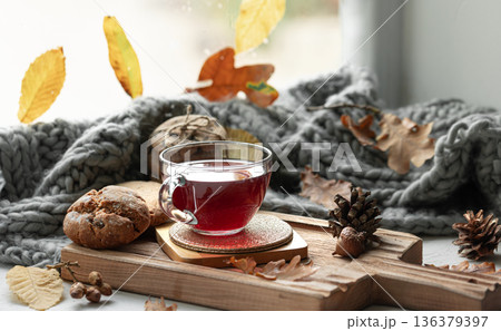 Autumn still life with a cup of tea, cookies and a knitted item. 136379397